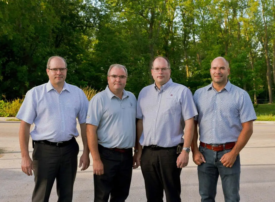 The Homestead Woodworks leadership team featuring four brothers, experts in custom woodwork solutions, standing outdoors.